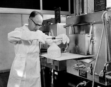 821201 Afbeelding van een proefneming met een oven in het laboratorium van de N.V. Nederlandse Staalfabrieken DEMKA ...